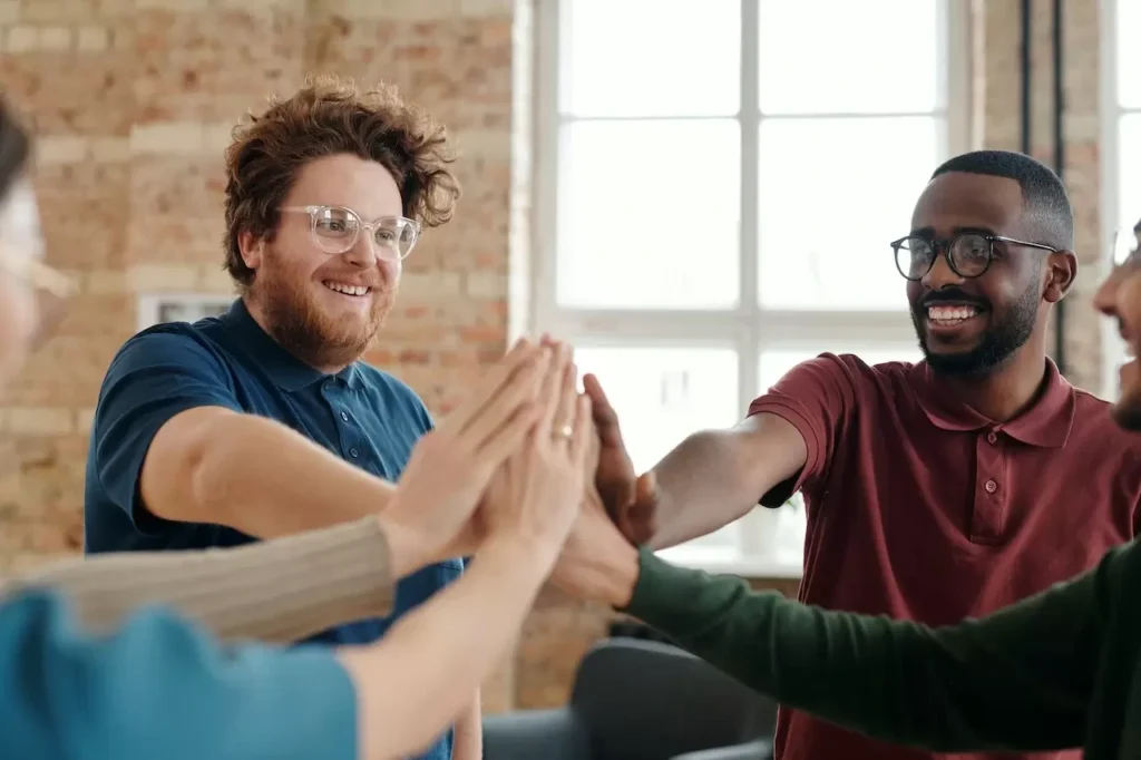 Group of diverse colleagues high-fiving in an office