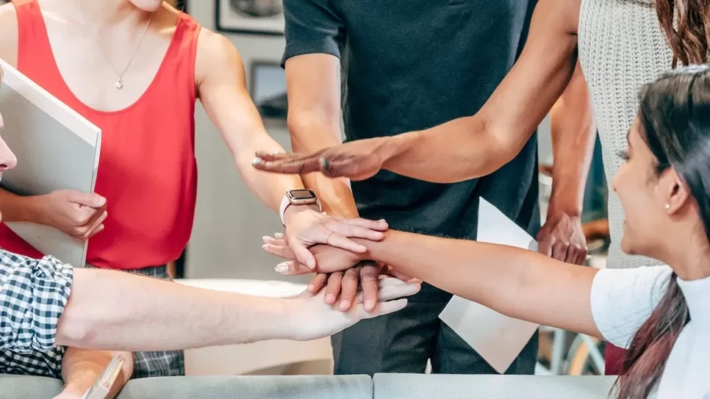 A diverse group of coworkers uniting hands in an office setting