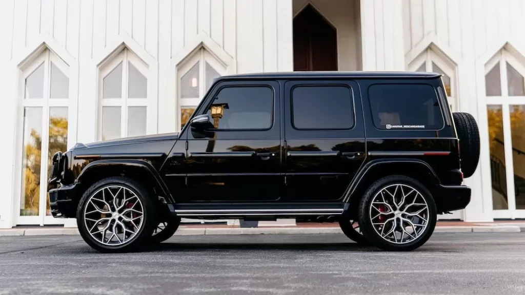 A sleek black SUV parked outside a stylish white building with geometric windows.