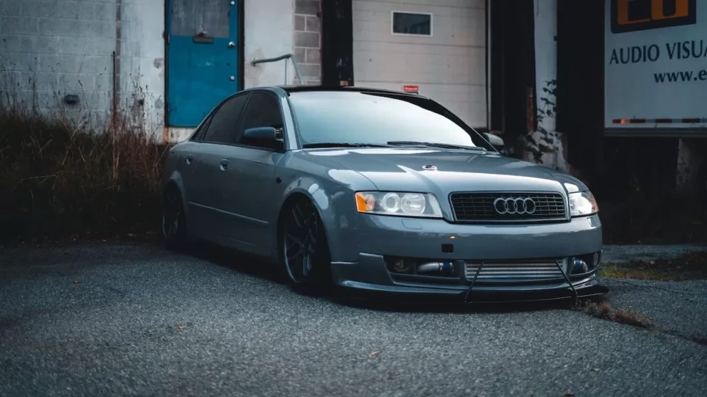 A luxury gray Audi sedan parked in an urban area, showcasing its shiny exterior and sporty design.