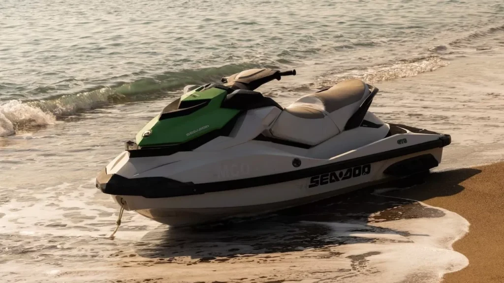 A jet ski resting on a sandy beach with gentle waves lapping at the shore