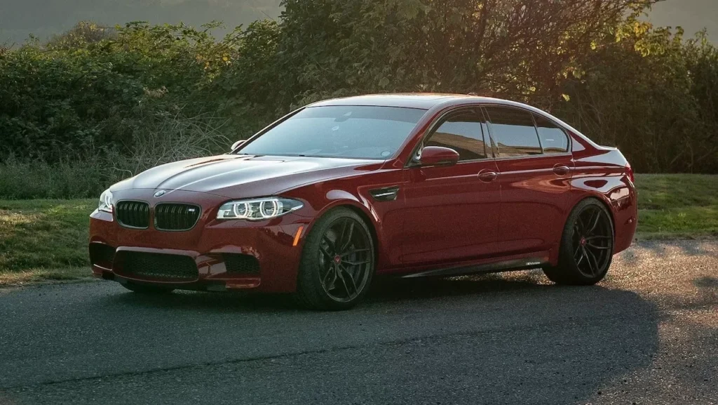 A luxurious red sedan parked on a scenic road during sunset, showcasing elegance and style