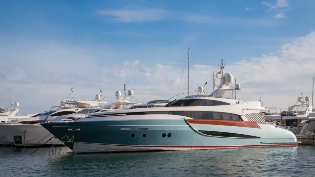 A collection of sleek yachts docked at a serene marina with a bright blue sky above