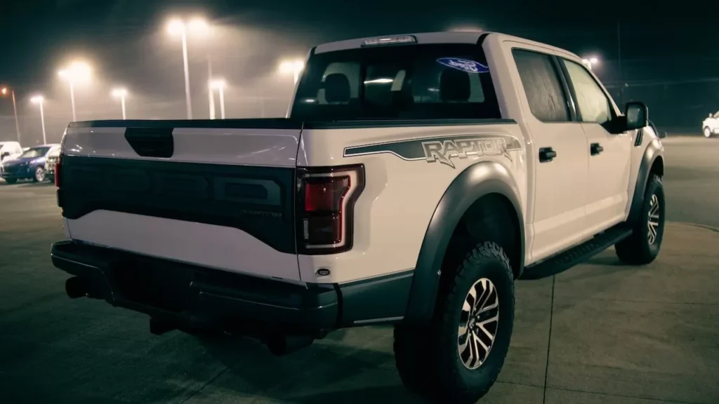 A white pickup truck parked at night under bright streetlights