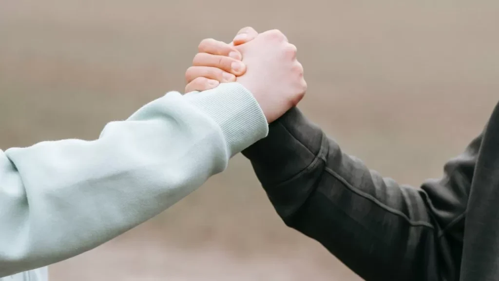 Two adults holding hands in an outdoor park setting