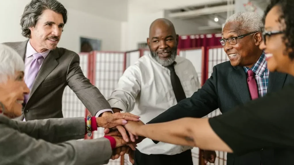Senior business team showing unity with hands together