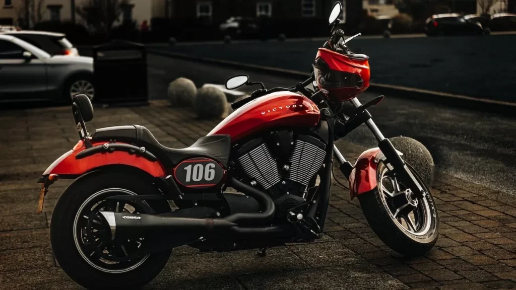 A sleek red sports motorcycle with number 106 parked on an urban pavement