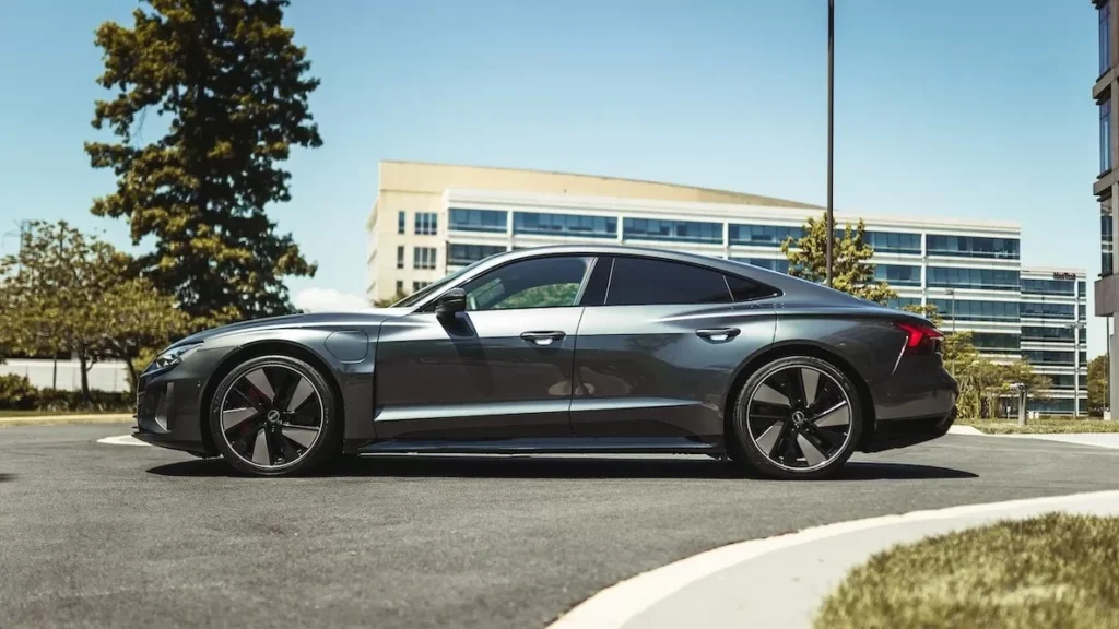 Side view of a sleek luxury car parked outdoors in a modern urban setting