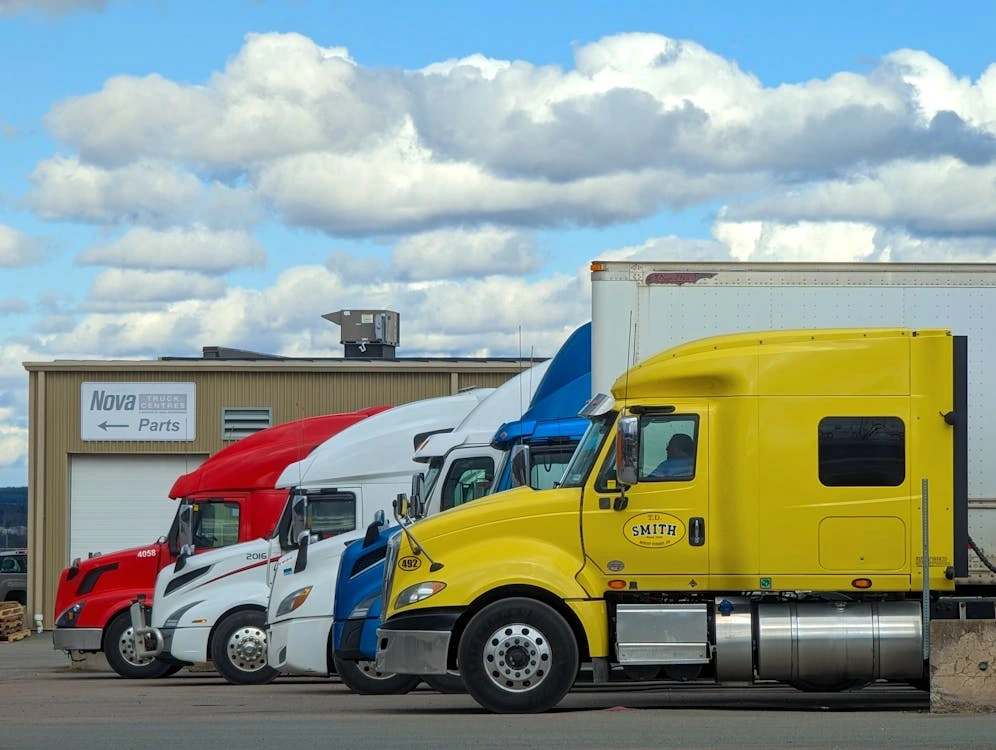 A vibrant lineup of semi trucks parked outside a Nova Truck Center in Truro, NS, Canada