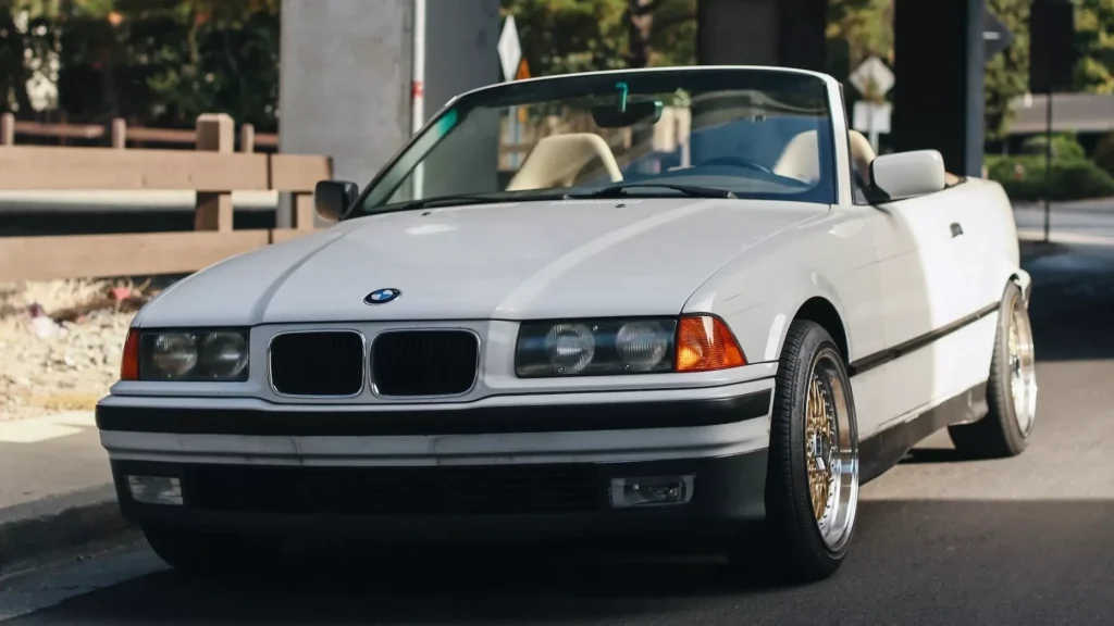 White BMW coupe parked near white concrete building during daytime