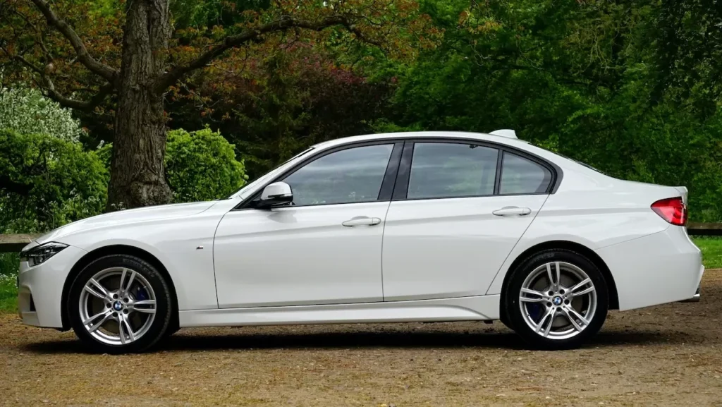 Side view of a sleek white luxury sedan parked outdoors