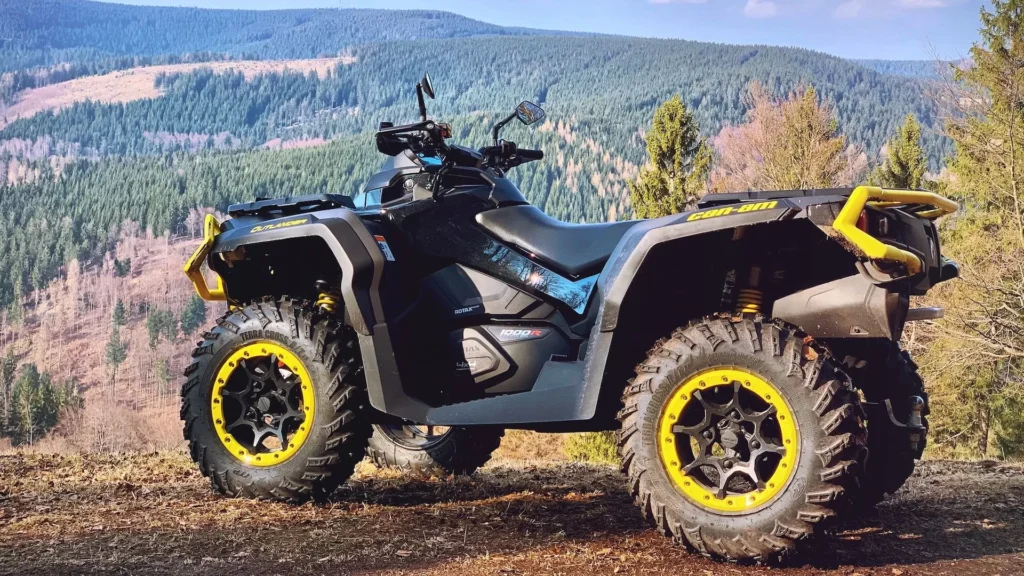 Yellow and black ATV on brown field under blue sky during daytime