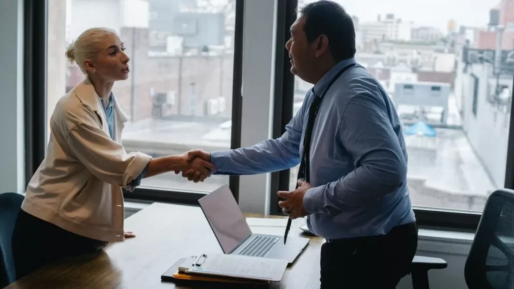 Professional handshake between two colleagues in a modern office setting